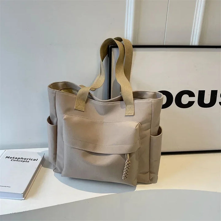 Sac de cours en toile robuste pour femme, design minimaliste et chic, parfait pour l'usage quotidien.