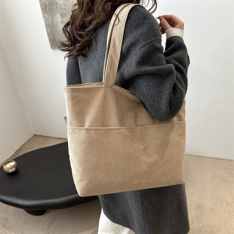 Sac cabas marron en velours côtelé, bandoulière ajustable, idéal pour femme, look hivernal chic.