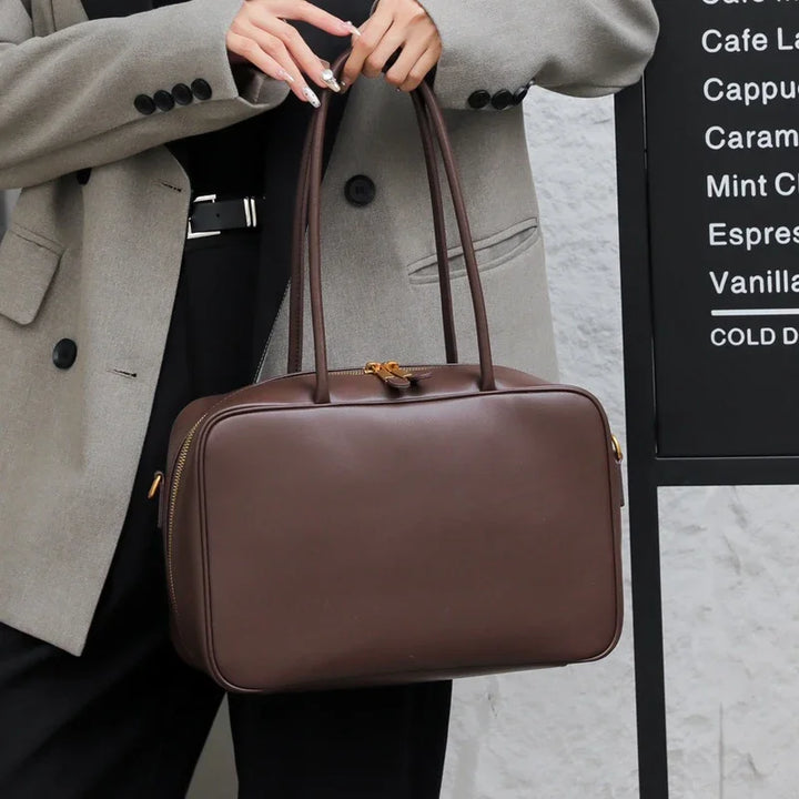 Sac épaule femme élégant blanc cassé en cuir souple, accessoire lumineux et chic pour le printemps.