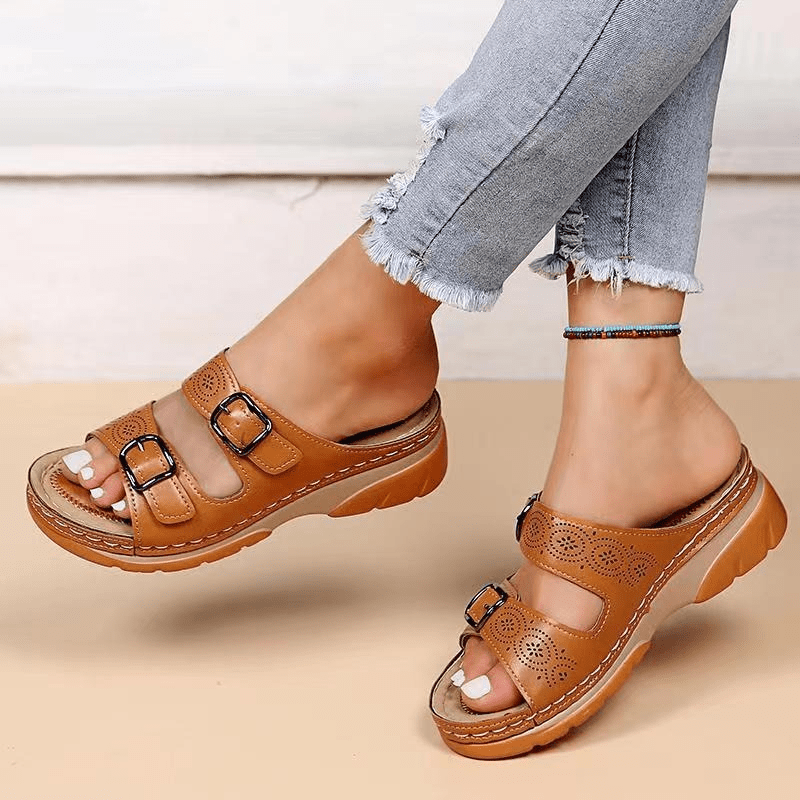Pieds de femme portant des sandales à doubles brides, confortables et stylées pour l'été.