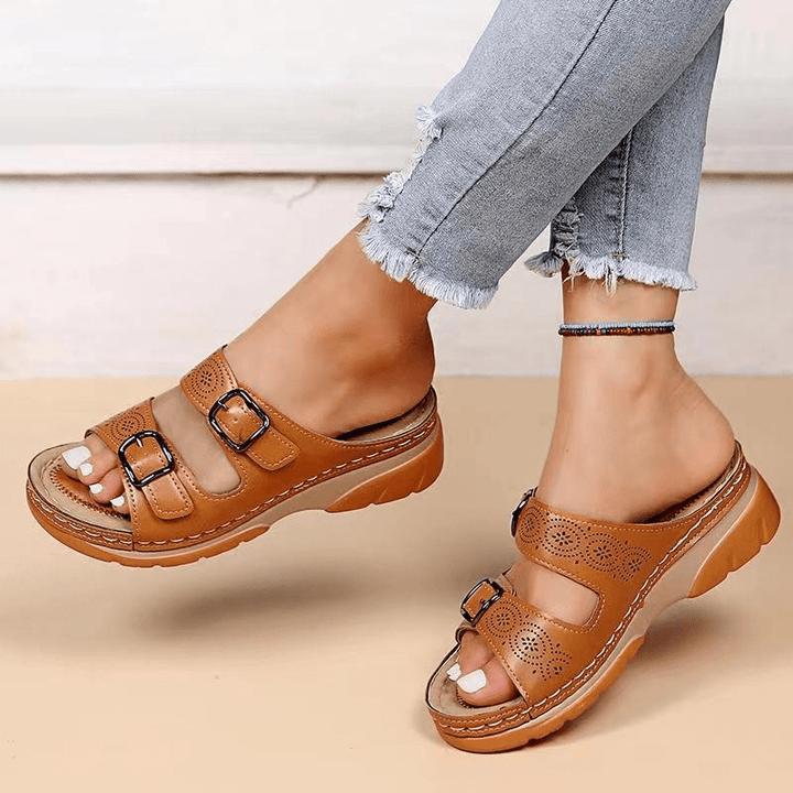 Pieds de femme portant des sandales à doubles brides, confortables et stylées pour l'été.