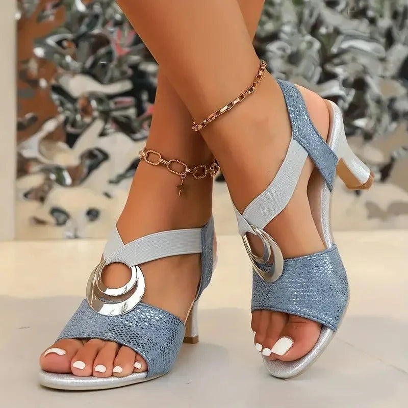 Sandales noires à talon fin pour femme, style chic avec boucles métalliques, parfaites pour la mode.