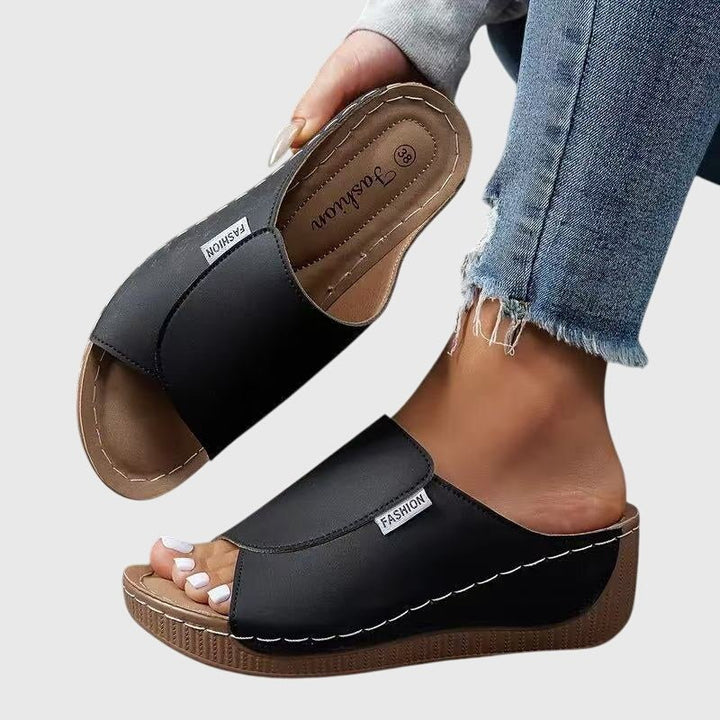 Pieds de femme portant des sandales compensées confortables et élégantes, parfaites pour l'été. Style décontracté.