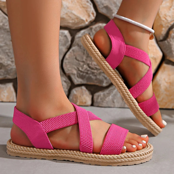 Vue rapprochée sandales plates orthopédiques noires femme. Brides croisées élégantes, confort assuré.