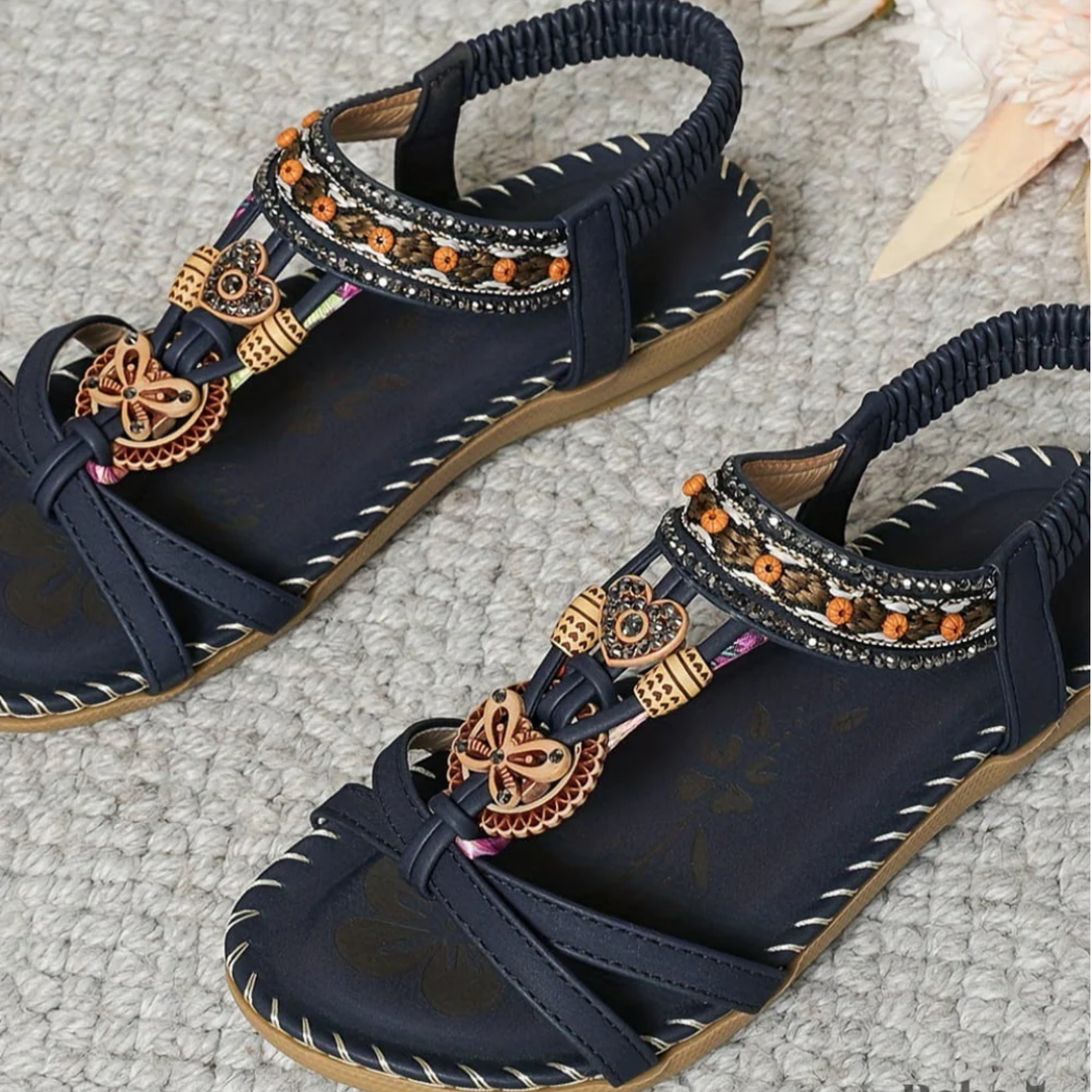 Détail gros plan sandales femme orthopédiques avec perles et lanières croisées, confort et support voûte plantaire.
