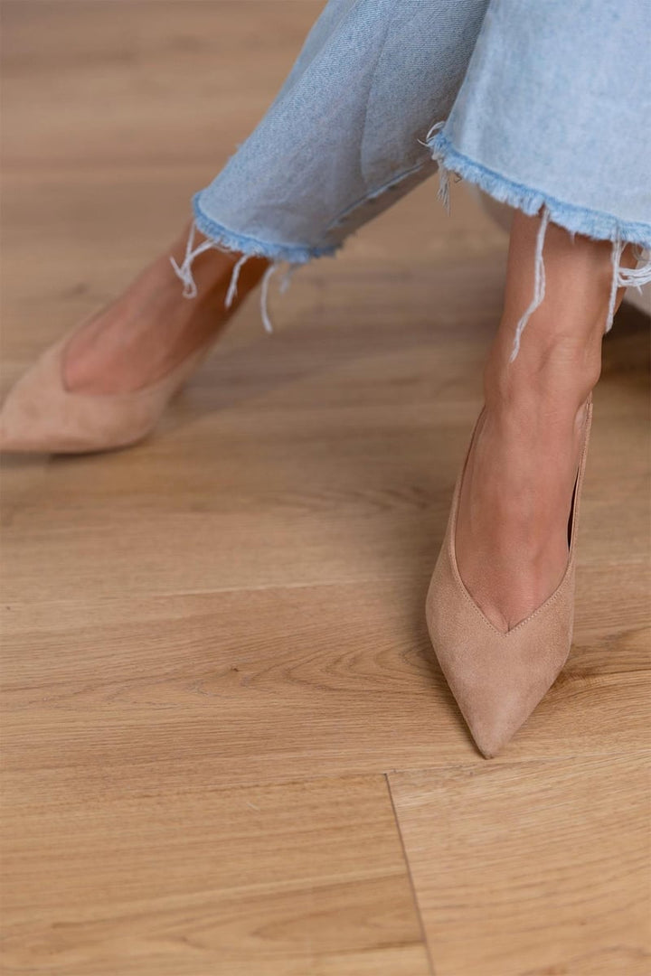 Gros plan sur escarpins beiges à talon fin. Chaussures élégantes femme, mode chic et polyvalente.