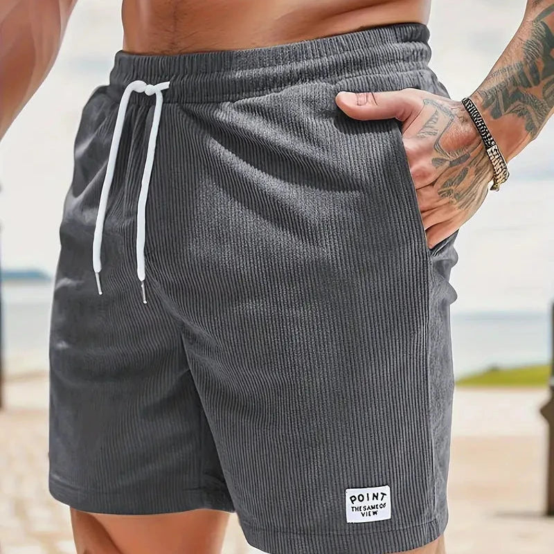 Homme portant un short décontracté ample avec taille à cordon, style casual d'été et printemps.