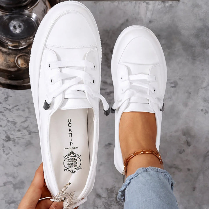 Sneakers basses femme à lacets, blanches. Design moderne et confort optimal pour un style décontracté et quotidien.