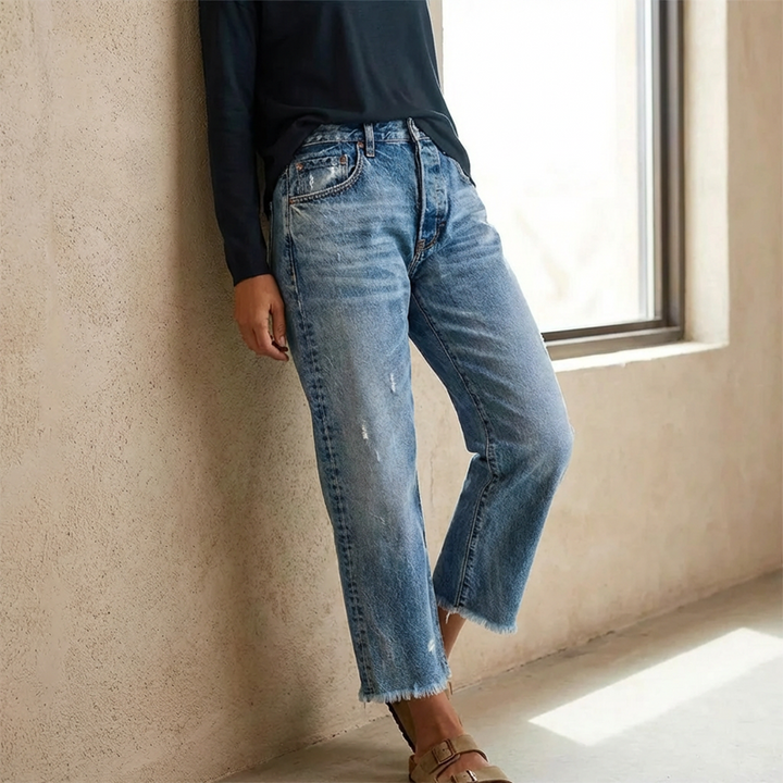 Femme portant un jean taille haute coupe droite cropped, look décontracté moderne.