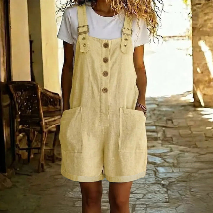 Détail de salopette courte femme vintage, montrant les bretelles réglables et les boutons.