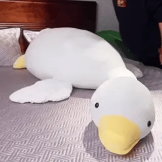 Coussin peluche oie géante, design moderne et texture douce. Jouet polyvalent et élément de décoration reposant.
