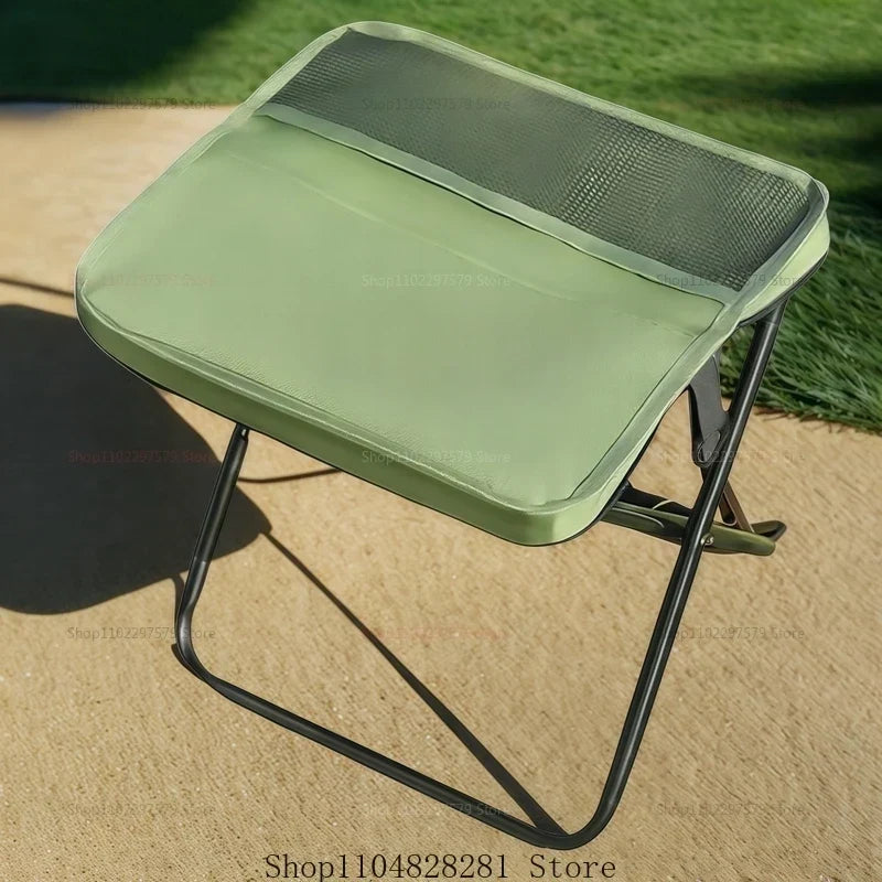 Tabouret de camping trépied pliable vert, équipement essentiel pour l'extérieur, la pêche et le pique-nique.