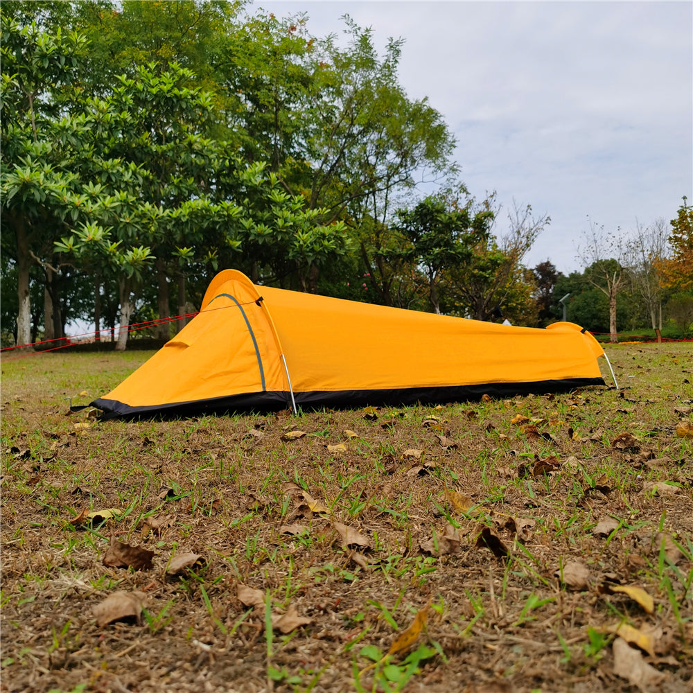 Tente bivouac ultralégère compacte emballée dans son sac, prête pour la randonnée et le camping en extérieur.