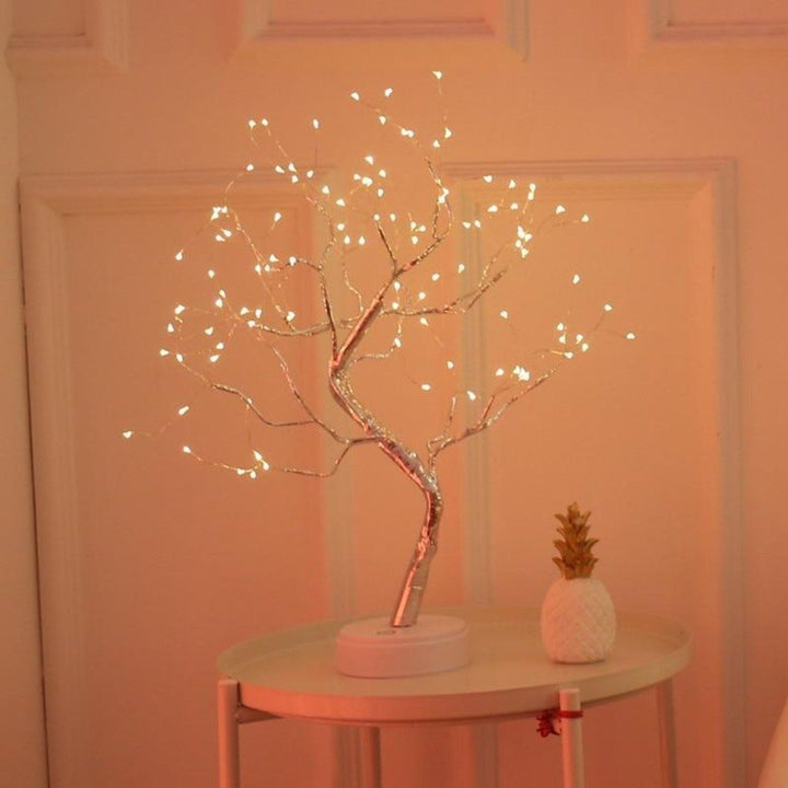 Lampe LED Arbre Bonsaï sur une table basse, créant une ambiance lumineuse relaxante. Décoration intérieure moderne.