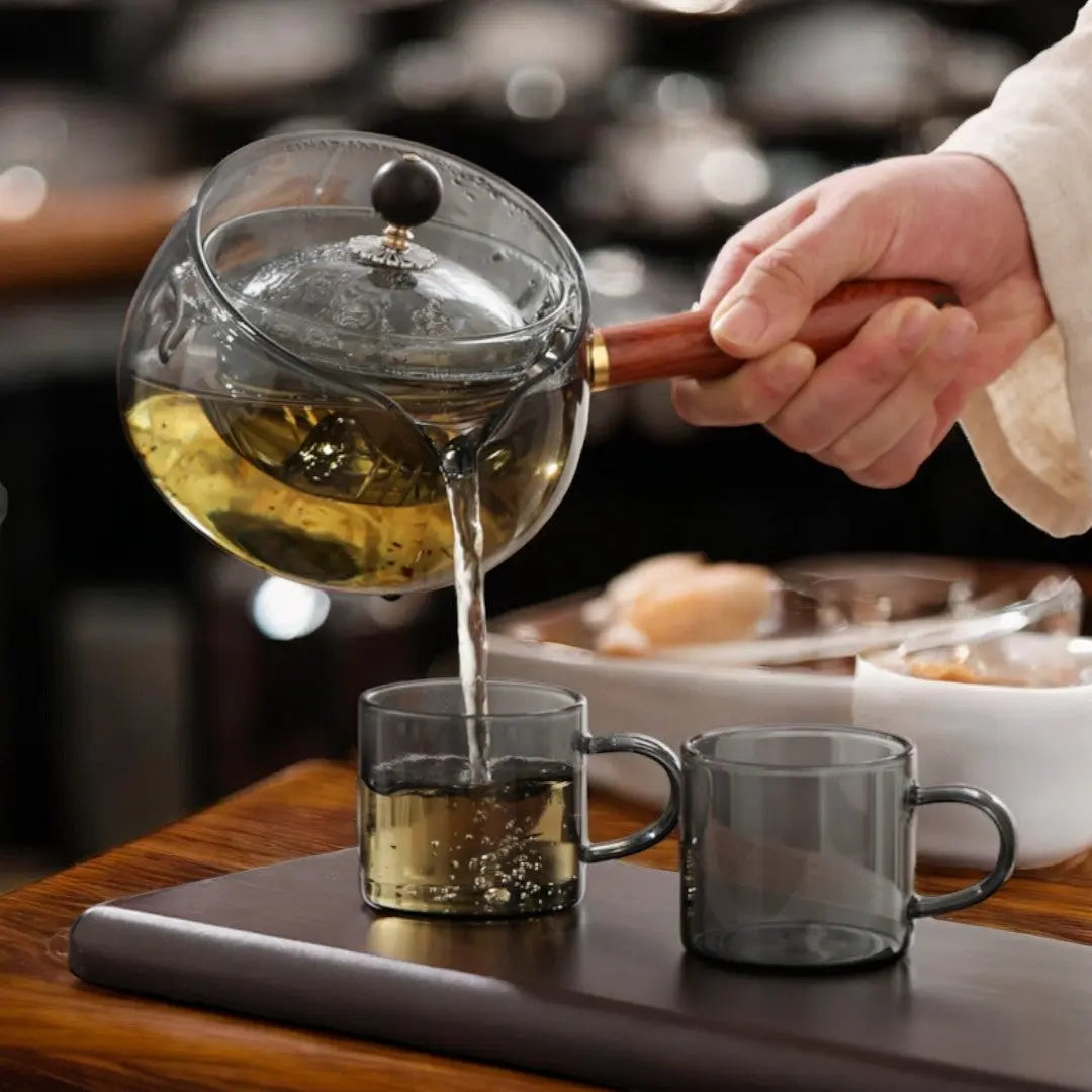 Théière rotative en verre borosilicate avec support en bois, pour une infusion du thé parfaite.