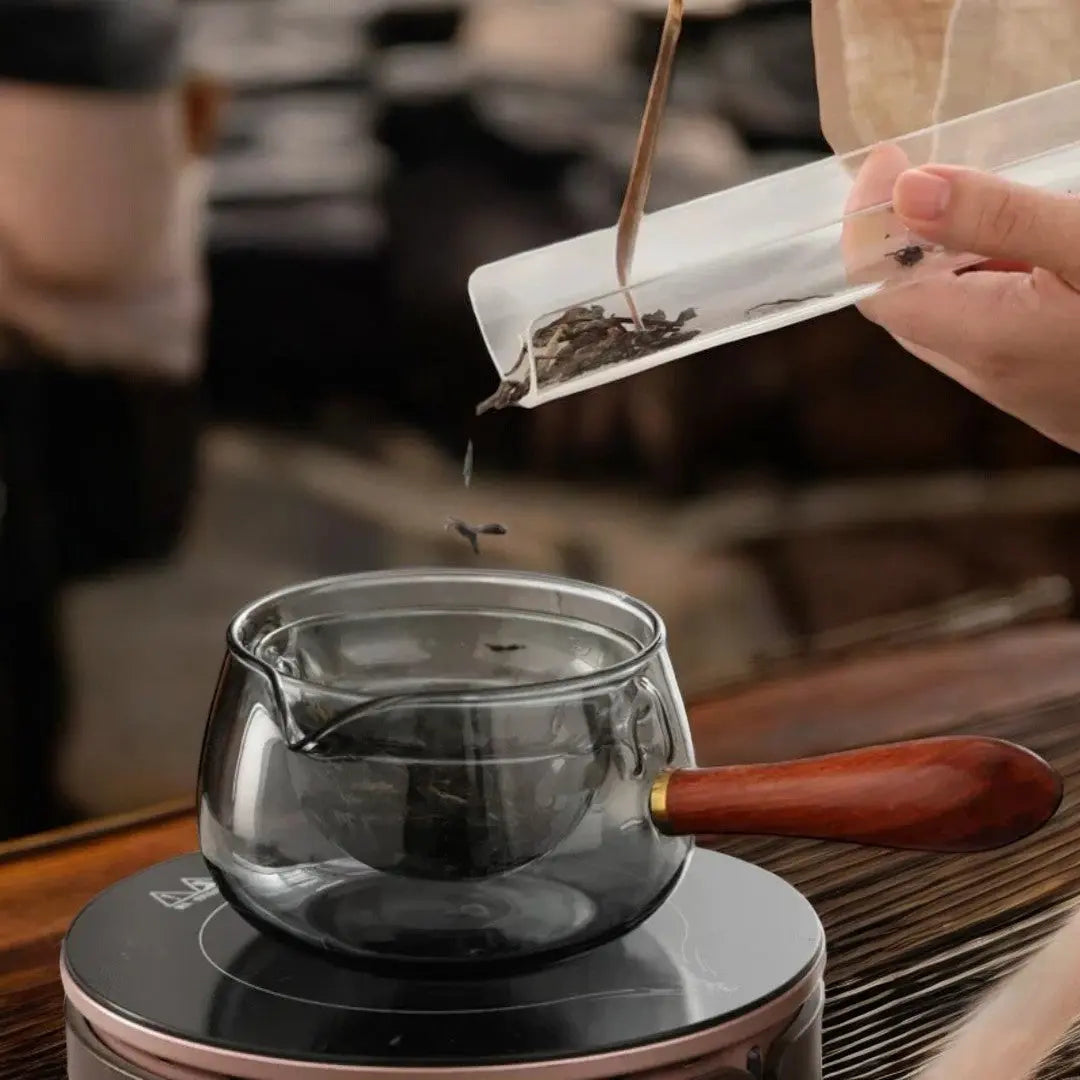 Élégante théière rotative en verre borosilicate et bois, ustensile de cuisine design.