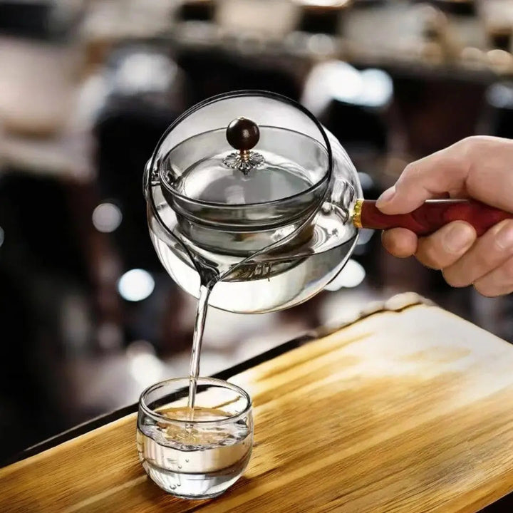 Théière rotative en verre sur une table de cuisine moderne, invitation à une pause thé.