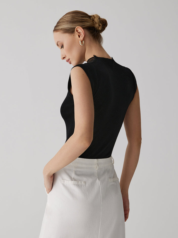 Haut femme moderne sans manches, col montant. Parfait pour soirée, ce top semi-transparent est très chic.