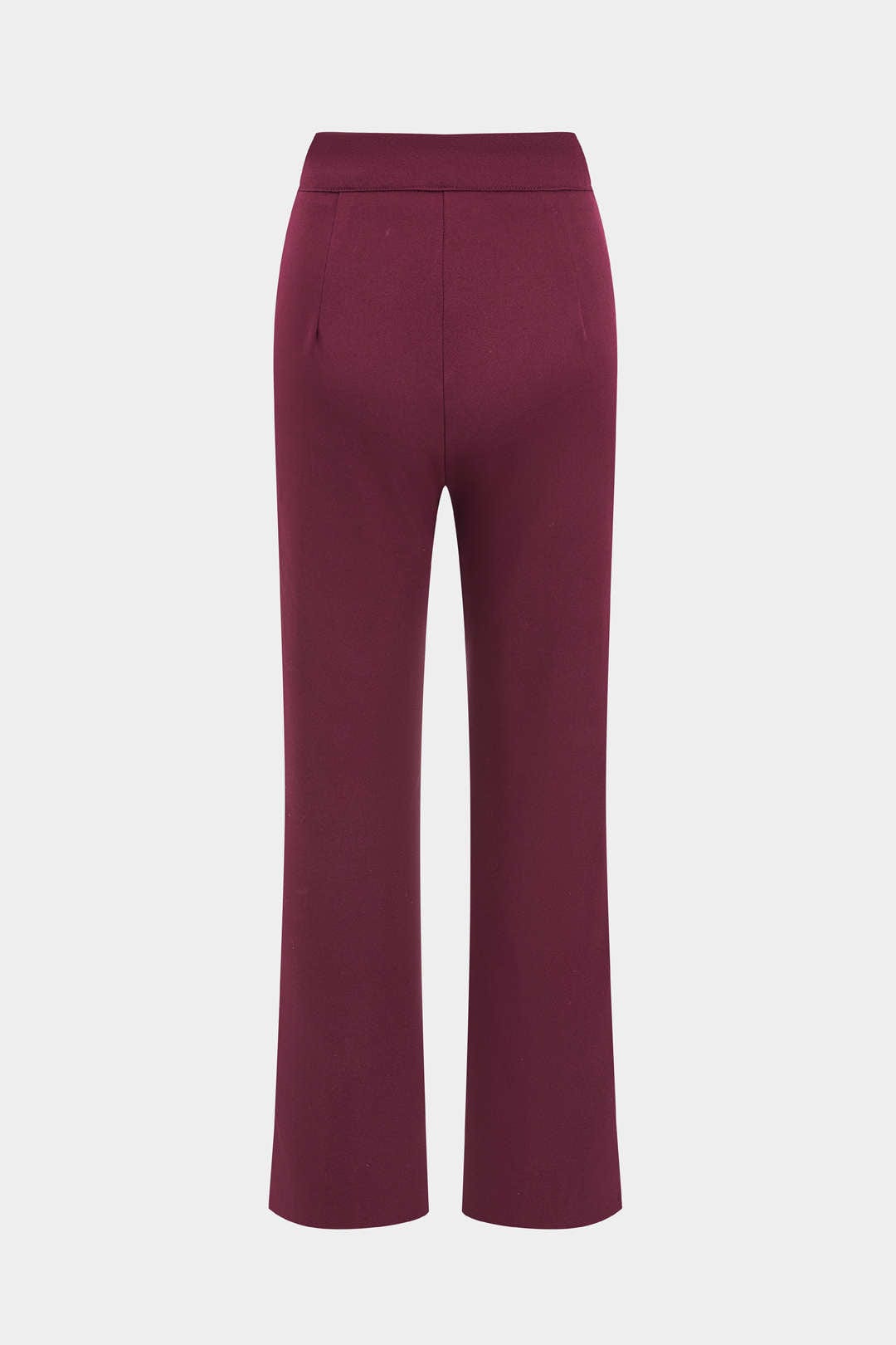 Femme élégante en costume deux pièces rouge : blazer ceinturé et pantalon droit, mode chic et moderne.