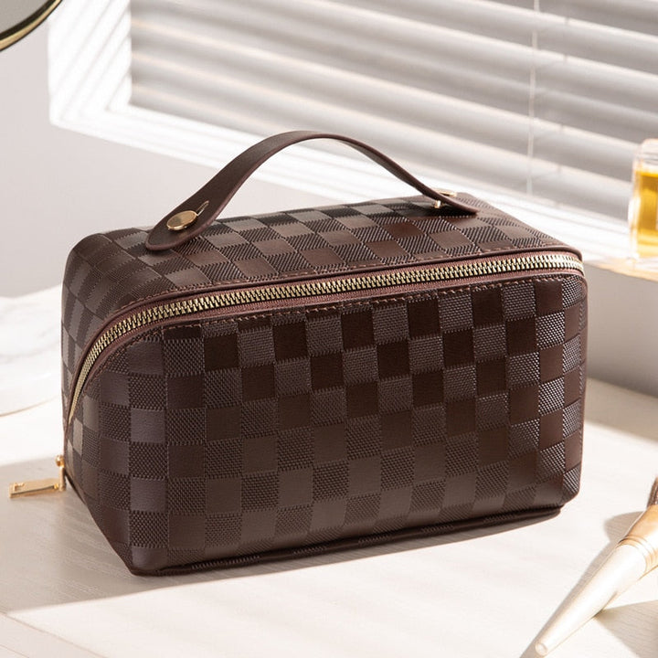 Accessoire de voyage femme: trousse maquillage à carreaux, organisateur beauté compact et élégant pour vos cosmétiques.