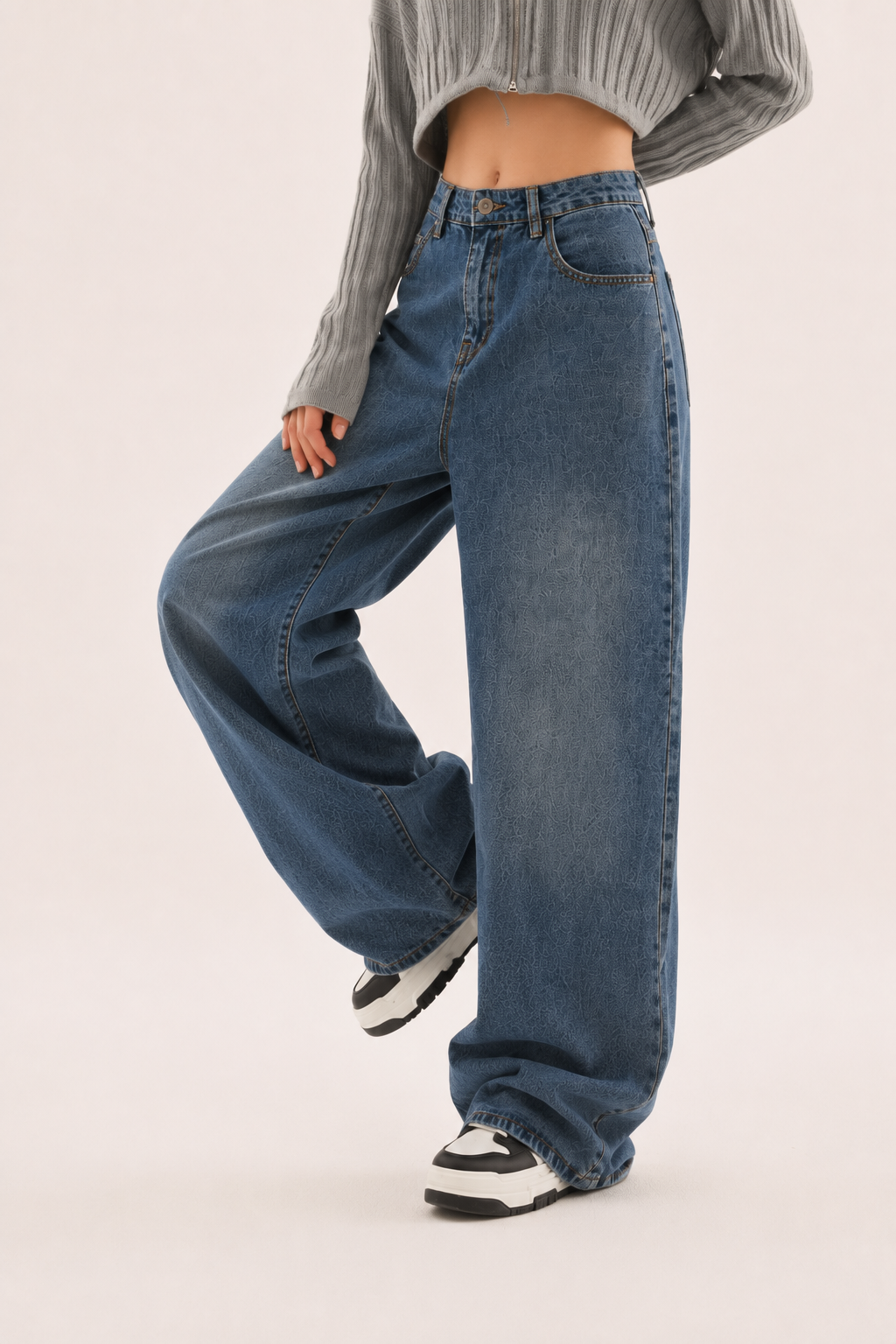 Jean femme taille haute bleu avec coupe large et coutures détaillées, un vêtement essentiel pour la mode féminine.