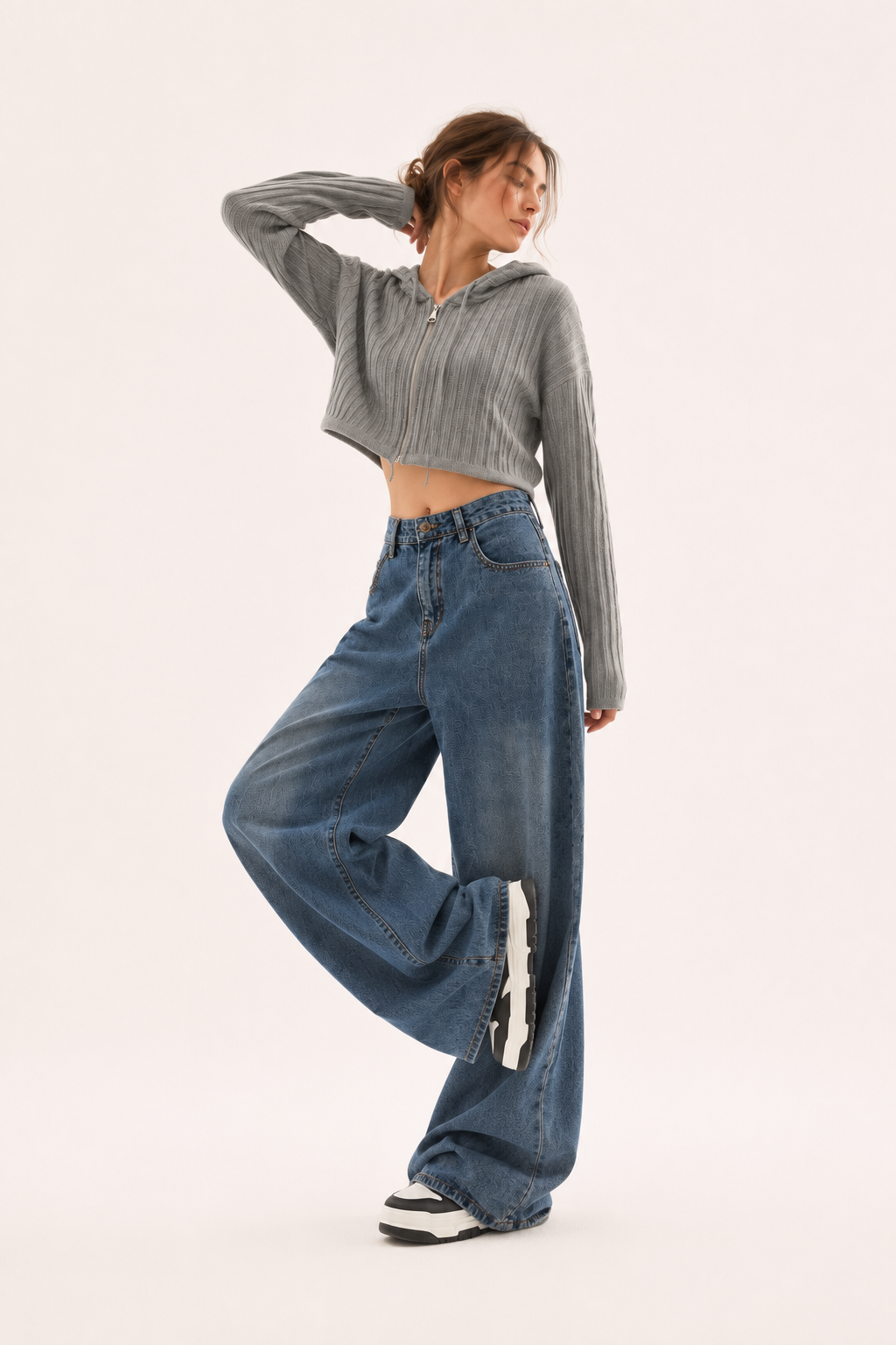 Gros plan sur les coutures apparentes d'un jean large taille haute bleu pour femme, soulignant son design mode.