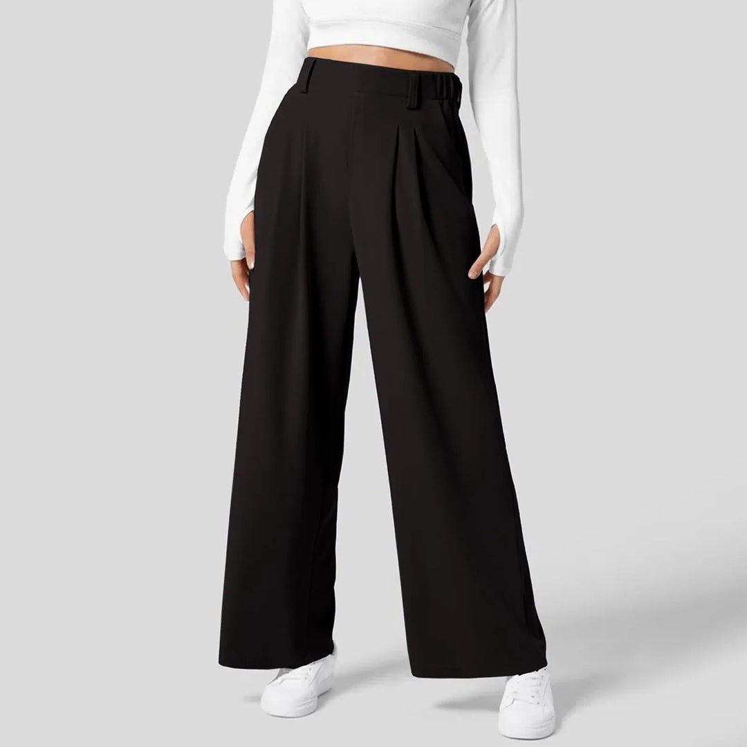 Modèle portant un pantalon large fluide rose clair taille haute. Confortable et chic, pour une silhouette élégante.