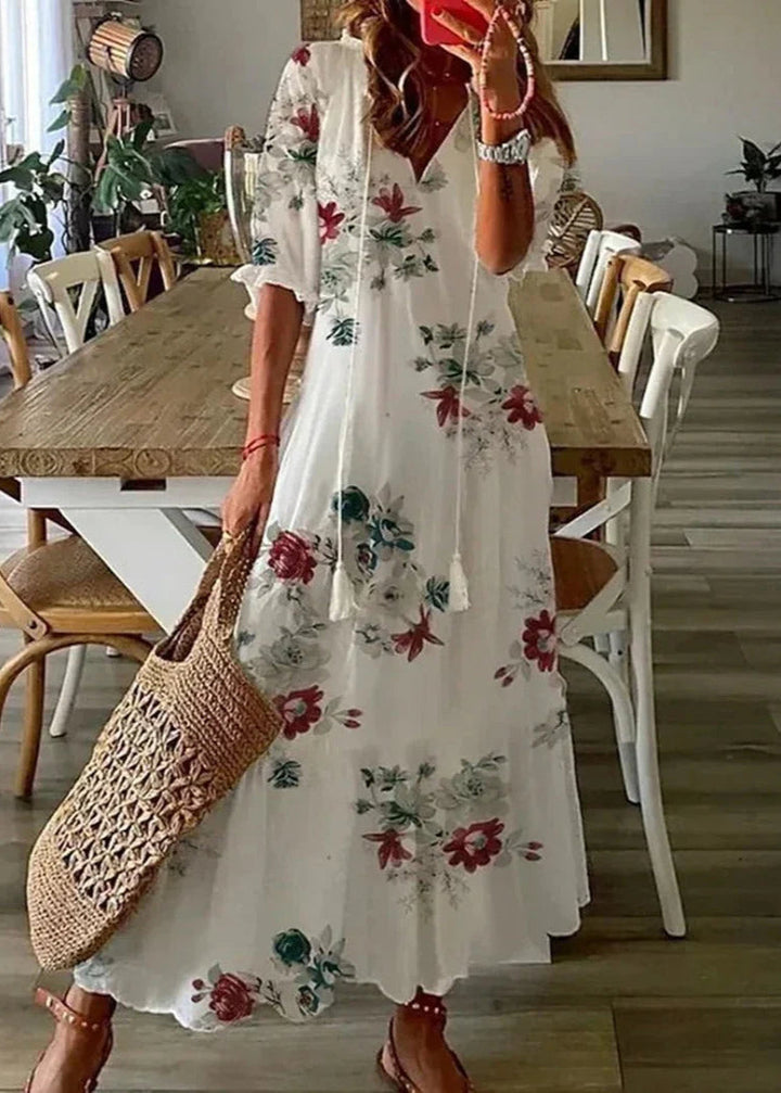Gros plan sur l'imprimé floral de la robe longue d'été femme, tissu léger et fluide. Style estival décontracté.
