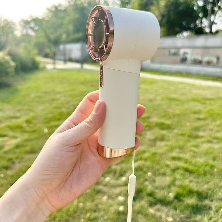 Femme utilisant un ventilateur à main numérique compact, parfait pour une fraîcheur discrète partout et tout le temps.